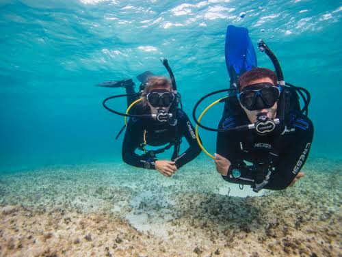 Dos buzos explorando las aguas del Caribe